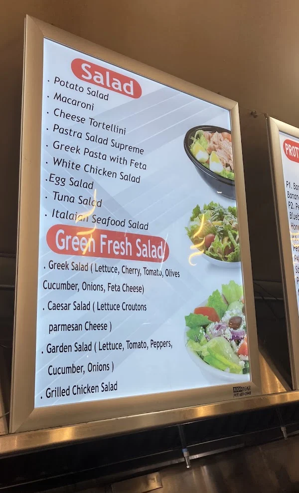 Salad menu board listing prepared salads and fresh green salads