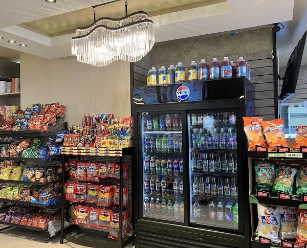 Snack racks and a drinks cooler under a glass light fixture