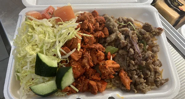 Takeout container with chicken, lamb, rice and salad